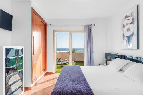 Un dormitorio con una cama y vista al mar. en MEDANO4YOU Sunrise Medano, en El Médano