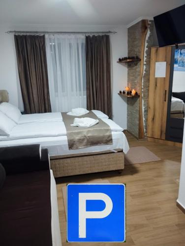 a hotel room with a large bed and a sign on the floor at Lela Kop in Kopaonik