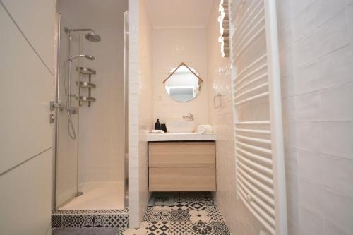 une salle de bains avec douche, lavabo et miroir dans l'établissement Cosy Studio Bourse Grands Boulevards, à Paris