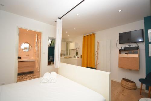 une chambre avec un lit blanc et une salle de bain dans l'établissement Cosy Studio Bourse Grands Boulevards, à Paris