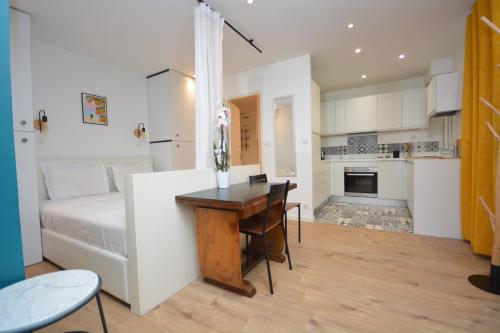 une chambre avec un lit et un bureau et une cuisine dans l'établissement Cosy Studio Bourse Grands Boulevards, à Paris