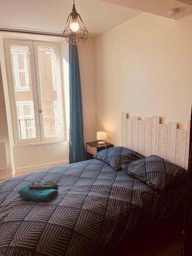 une chambre avec un lit avec un oreiller dessus dans l'établissement App du prince centre-ville Aurillac 2 pers, à Aurillac