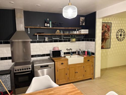 une cuisine avec une cuisinière et un évier dans l'établissement La Gravelinoise, à Gravelines