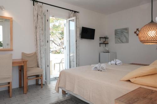 a bedroom with a bed and a desk and a window at Angela's Rooms in Mýkonos City