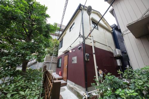 a small house with a red door next to a building at The Villa Ebisu RED惠比寿駅徒步8分静かな住宅地 in Tokyo