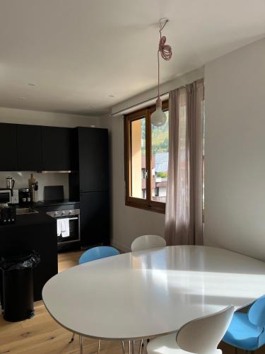 - une table et des chaises blanches dans la chambre dans l'établissement Appartement Oliver, à Chamonix-Mont-Blanc