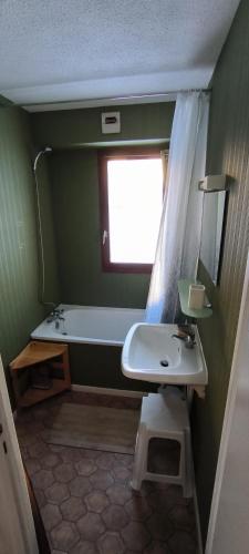 La salle de bains est pourvue d'un lavabo, d'une baignoire et d'une fenêtre. dans l'établissement Appartement au pied des pistes, à Albiez-Montrond