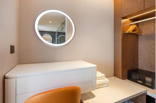 a dressing room with a mirror above a white dresser at Sanyu Hotel in Guangzhou