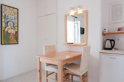 a kitchen with a wooden table and chairs and a mirror at Angela's Rooms in Mýkonos City