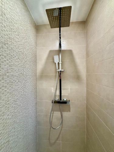une douche avec pommeau de douche dans une salle de bain dans l'établissement VillaPalmaé1, à Lapalme