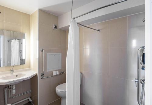 a bathroom with a toilet and a sink at B&B HOTEL Bordeaux Lac sur Bruges in Bruges