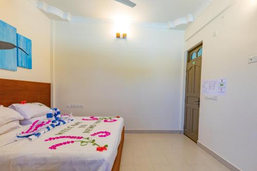 a bedroom with a bed with flowers on it at Nemo Inn in Omadhoo