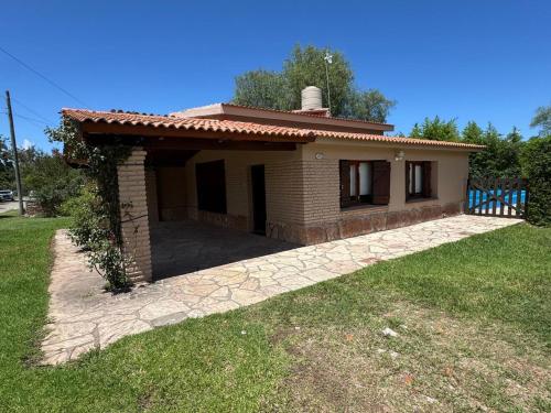ein kleines Backsteinhaus mit einem Rasenplatz in der Unterkunft CASA PARA 6 PERSONAS MERLO SAN LUIS in Merlo
