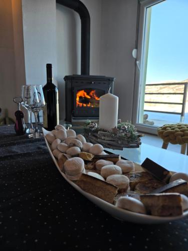 a plate of rocks and a candle on a table with a fireplace at Forest Panorama Cabin Brezna in Pluzine