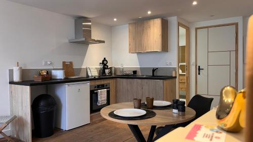 ベラックにあるStudio cosy idéal pour Séjours Courts ou Longsのテーブルとカウンタートップのあるキッチン