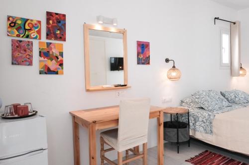 a room with a table and a bed and a mirror at Angela's Rooms in Mýkonos City