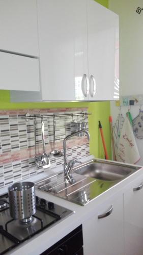 a kitchen with a sink and a stove at Donkey on the Beach in Cobbs Cross