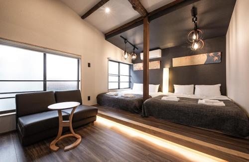 a bedroom with two beds and a couch and a table at The Villa Ebisu BLUE惠比寿駅徒步8分 静かな住宅地 in Tokyo