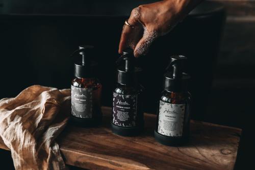 a person holding two bottles of chili sauce at Jufenalm BOHO & Wellnesshotel in Maria Alm am Steinernen Meer