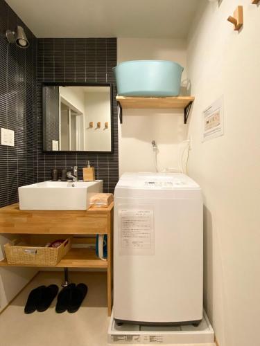 a small bathroom with a sink and a refrigerator at The Villa Ebisu BLUE惠比寿駅徒步8分 静かな住宅地 in Tokyo