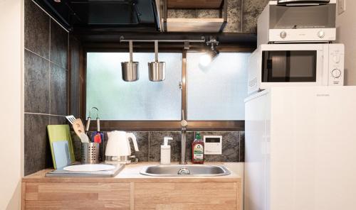 a kitchen with a sink and a white refrigerator at The Villa Ebisu BLUE惠比寿駅徒步8分 静かな住宅地 in Tokyo