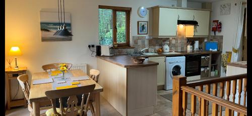 a kitchen with a table and a dining room at The Nineteenth, Oakridge St Mellion, Free Golf/SPA in St. Mellion