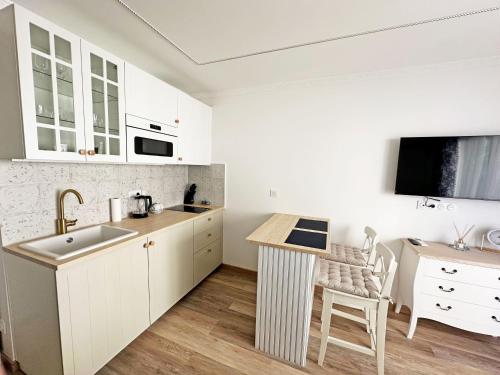 - une cuisine avec des placards blancs, un évier et une table dans l'établissement Stunning Studio Rue France Promenade des Anglais, à Nice