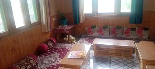 a living room with a couch and a table at Thakur Niwas in Manāli