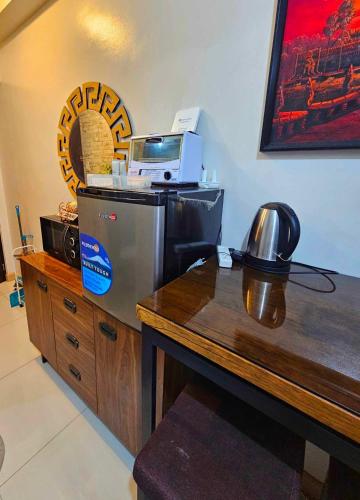 eine Küche mit Kühlschrank und Holztisch in der Unterkunft Cloud Studio at Northpoint in Davao City