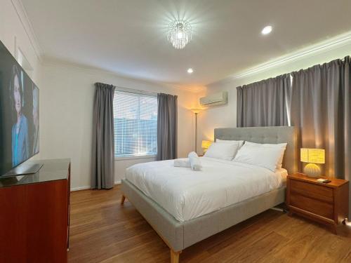 a bedroom with a bed and a dresser and a television at All-Seasons Comfort - Close to CBD & Air port in Warrane