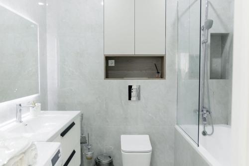 a bathroom with a toilet and a sink and a shower at Комфорт сити in Almaty