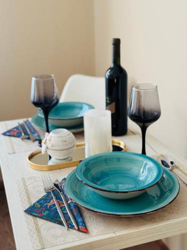 un tavolo con un piatto blu e bicchieri da vino di Bella Studio a Podgorica