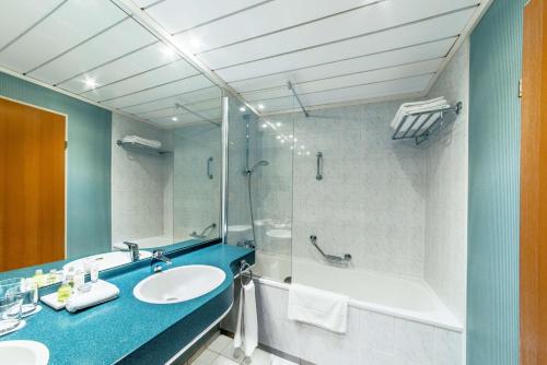 a bathroom with a tub and a sink and a shower at NH Prague City in Prague