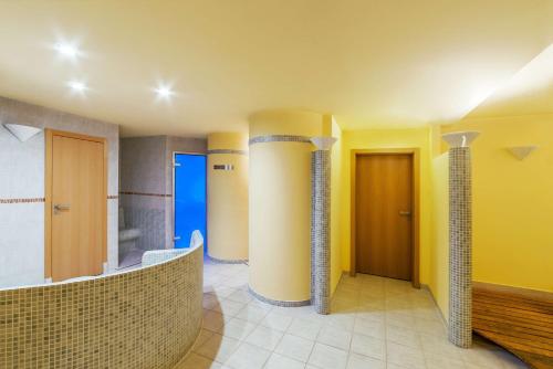a bathroom with yellow walls and columns in a room at NH Prague City in Prague