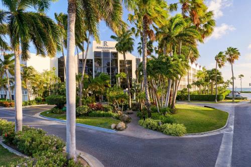a street with palm trees in front of a building at Renaissance Wind Creek Aruba Resort in Oranjestad