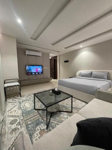 a bedroom with a bed and a couch and a tv at Darwish hostel in Jeddah