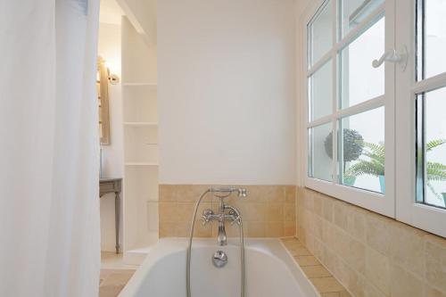 une baignoire dans une salle de bain avec une fenêtre dans l'établissement Maison au coeur du Marais - II, à Paris