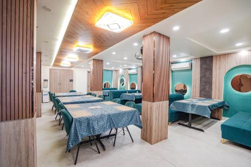 a dining room with tables and blue chairs at FabHotel Shrinath Casa Inn in Bhopal
