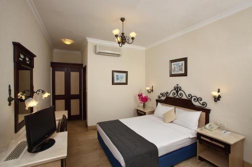 a bedroom with a bed and a desk with a computer at Cactus Fleur Beach in Yalıkavak