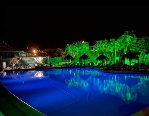 a swimming pool with green lights in the night at T1 Gardénia in Le Diamant