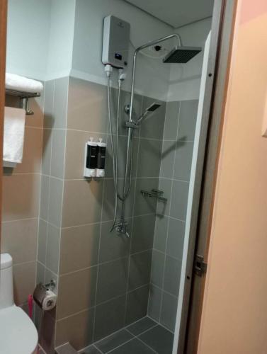 a bathroom with a shower with a glass door at La Chicka Staycation in Coast Residences in Manila