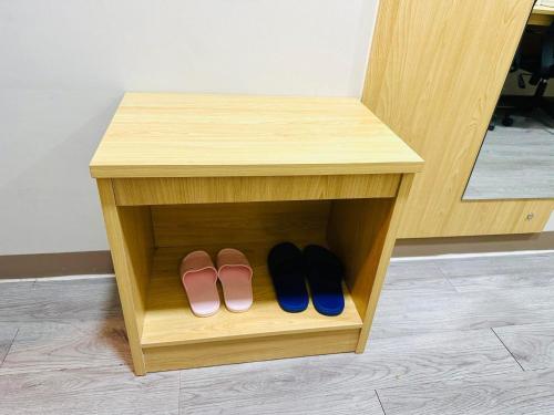 a shelf with two pairs of shoes in a stool at La Chicka Staycation in Coast Residences in Manila