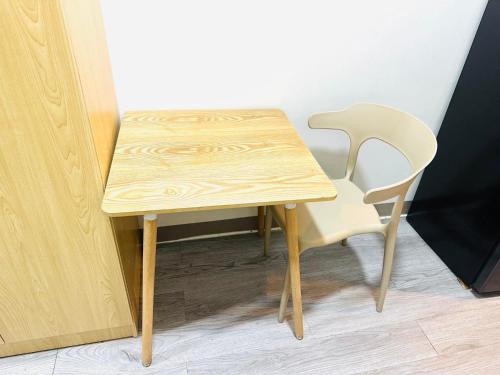 a wooden table and a chair next to a table at La Chicka Staycation in Coast Residences in Manila