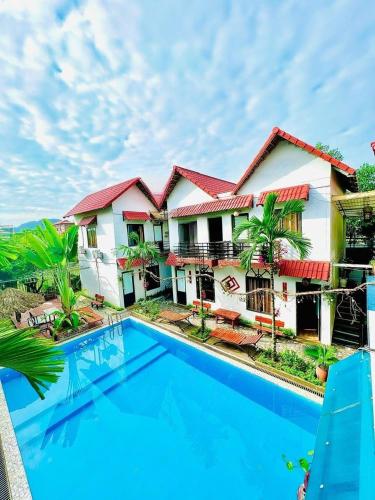a house with a swimming pool in front of it at Tam Coc Mandala Villa & Homestay in Ninh Binh