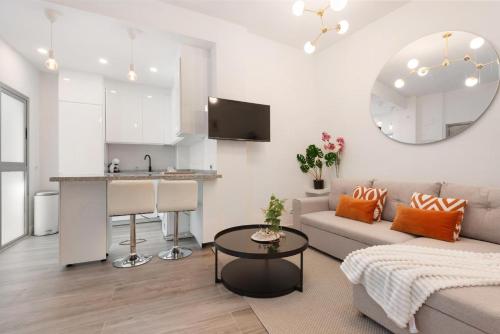 een witte woonkamer met een bank en een tafel bij Menaleka's House 7 in Málaga