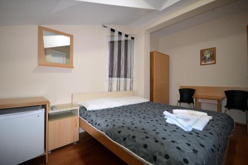 - une chambre avec un lit, un lavabo et un miroir dans l'établissement Mitko's Guest House, à Ohrid