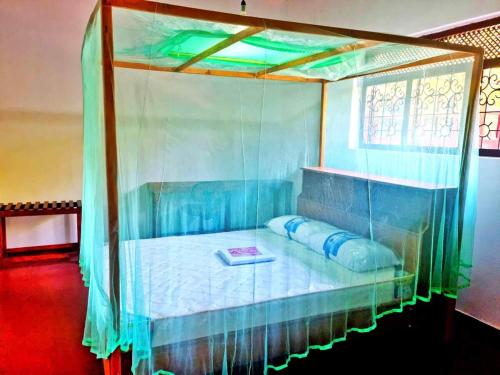 a bedroom with a canopy bed in a room at Stylish Escape House-Walk to Beach Vacation Rental Hikkaduwa in Hikkaduwa
