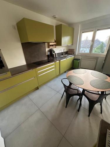 - une cuisine avec une table, une table et des chaises dans l'établissement Vaste appartement avec parking gratuit, borne dispo et espace de travail, à Illkirch-Graffenstaden