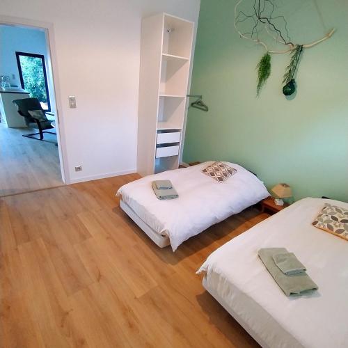 a room with two beds and a ladder on the wall at Charmant Cottage in Châtenois