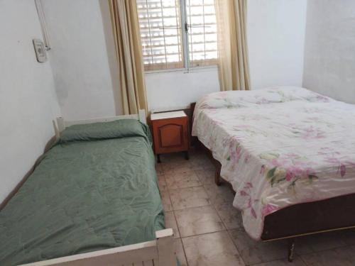 a bedroom with two beds and a window at El Descanso cabaña in Cavalango